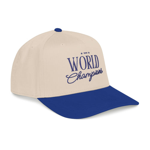A two-tone baseball cap with an off-white crown and a royal blue brim, featuring '1999 World Champions' embroidered in blue on the front.