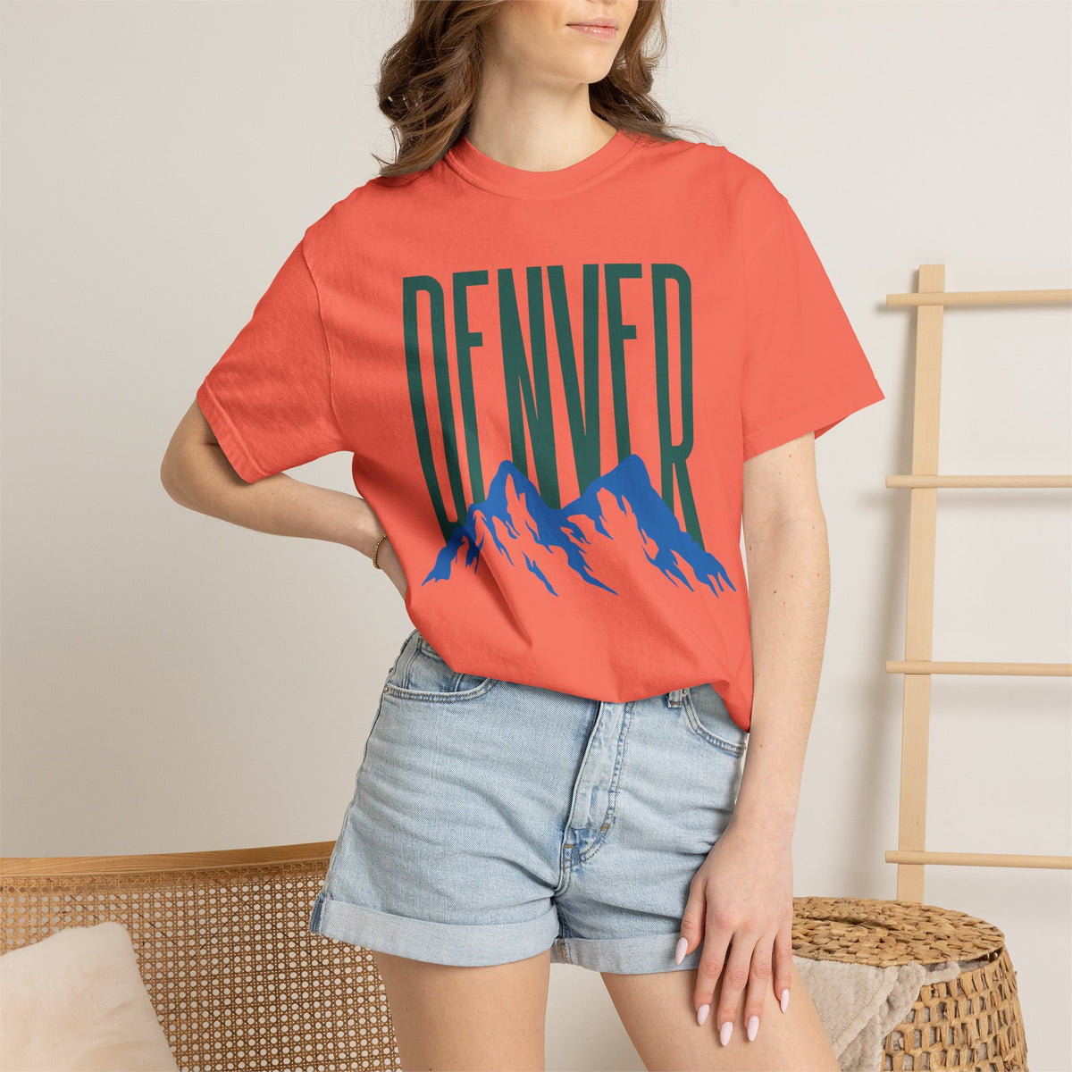 Bright Salmon Denver mountain graphic t-shirt featuring block lettering above a blue Rocky Mountain silhouette, ideal for game day fan gear.