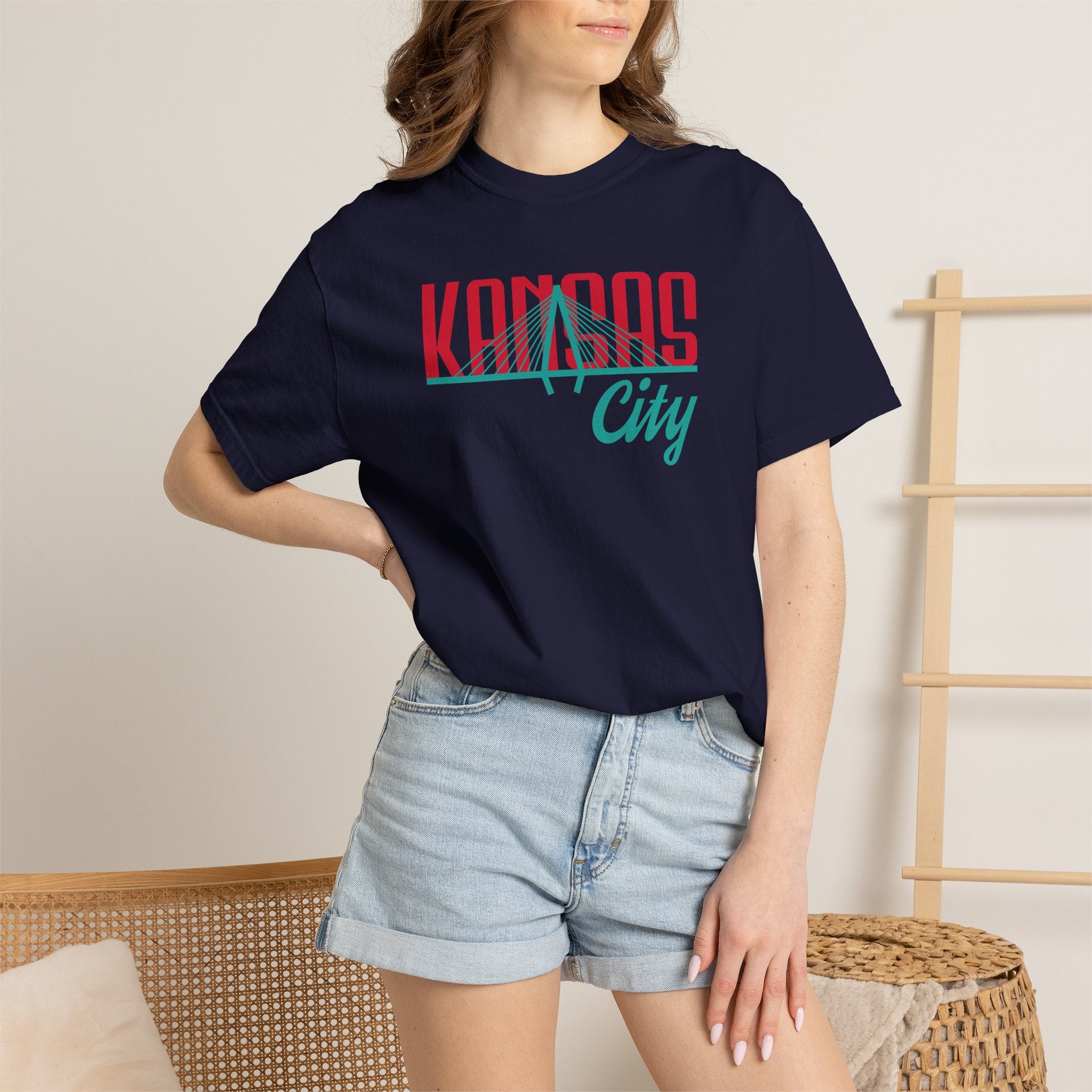 Navy garment-dyed t-shirt front view featuring "Kansas City" with bridge graphic in red and teal retro script across the chest.