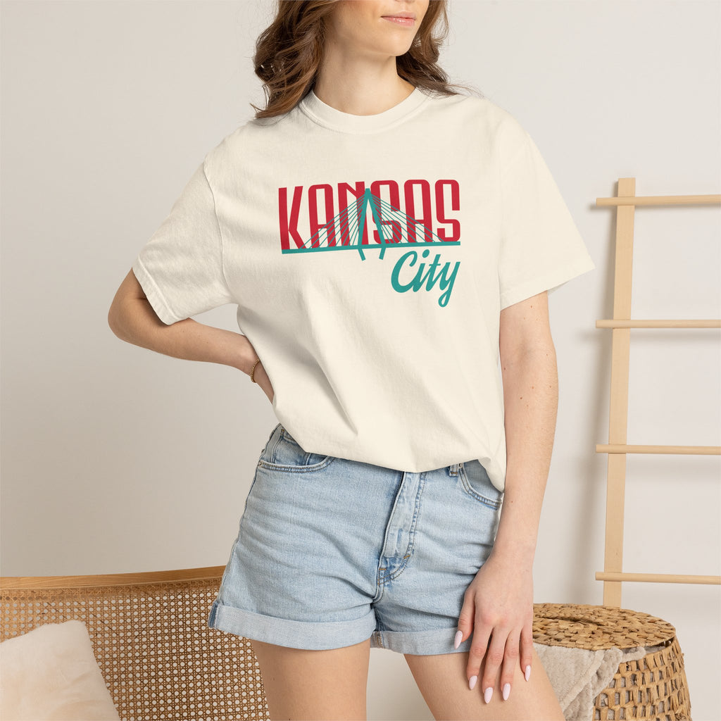 Ivory garment-dyed t-shirt front view featuring "Kansas City" with bridge graphic in red and teal retro script across the chest.