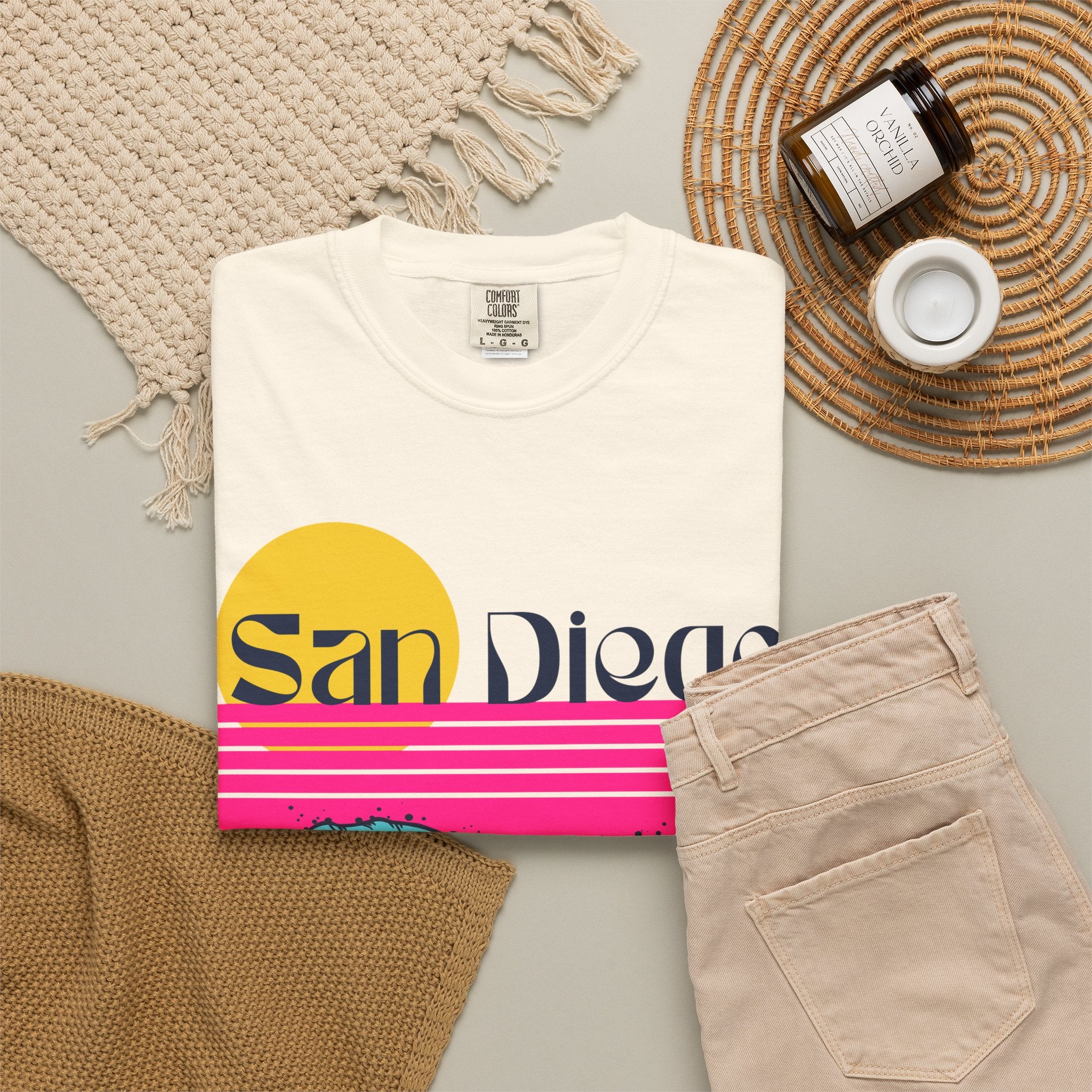 Ivory short-sleeve crewneck t-shirt featuring a retro-style sunset and ocean waves graphic with the text 'San Diego' across the chest