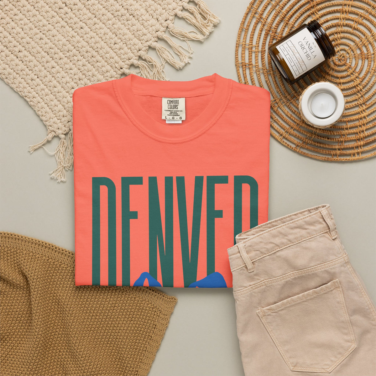 Bright Salmon Denver mountain graphic t-shirt featuring block lettering above a blue Rocky Mountain silhouette, ideal for game day fan gear.