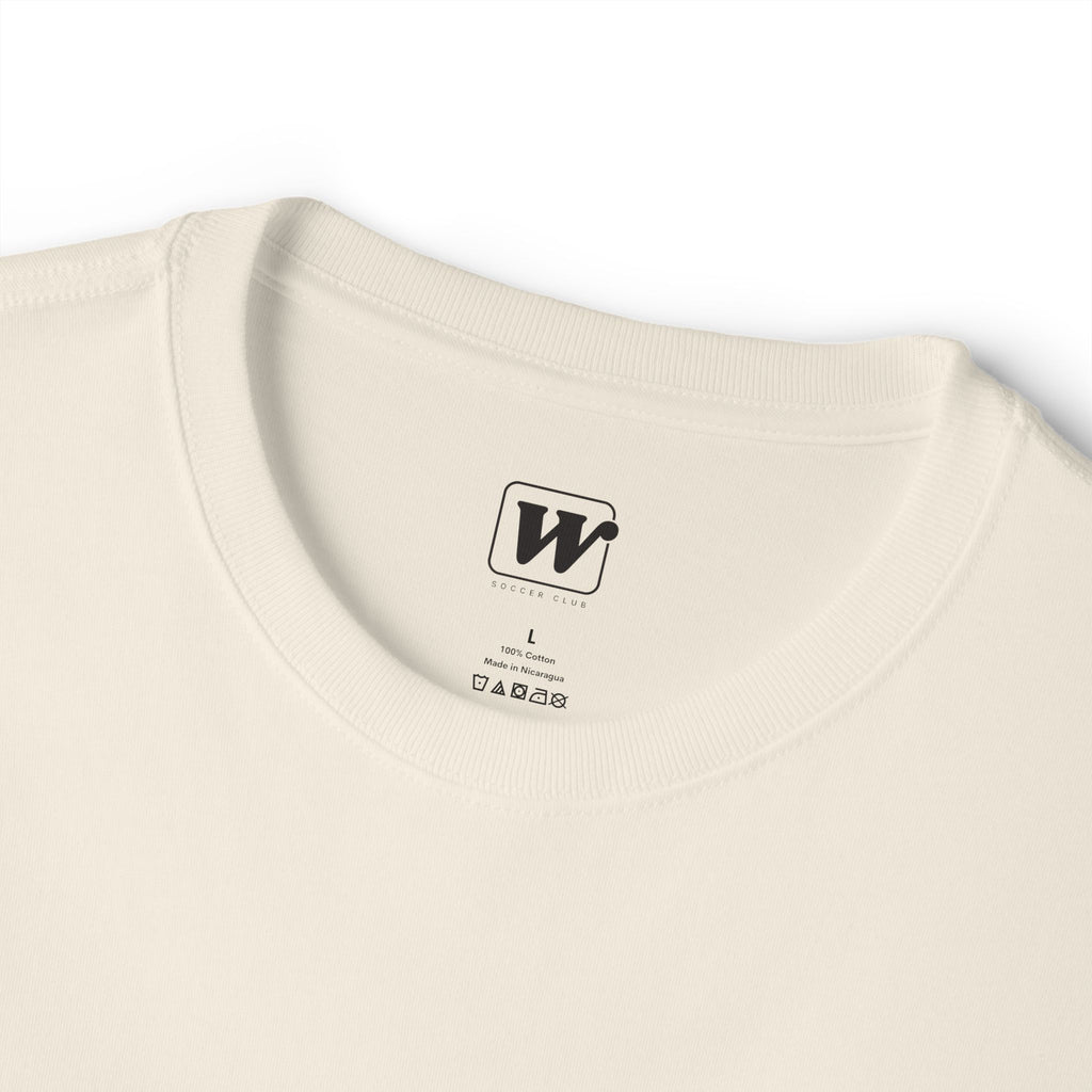 Natural colored 'Elite Company Only' boxy t-shirt close-up showing the W Soccer Club logo on the inside tag