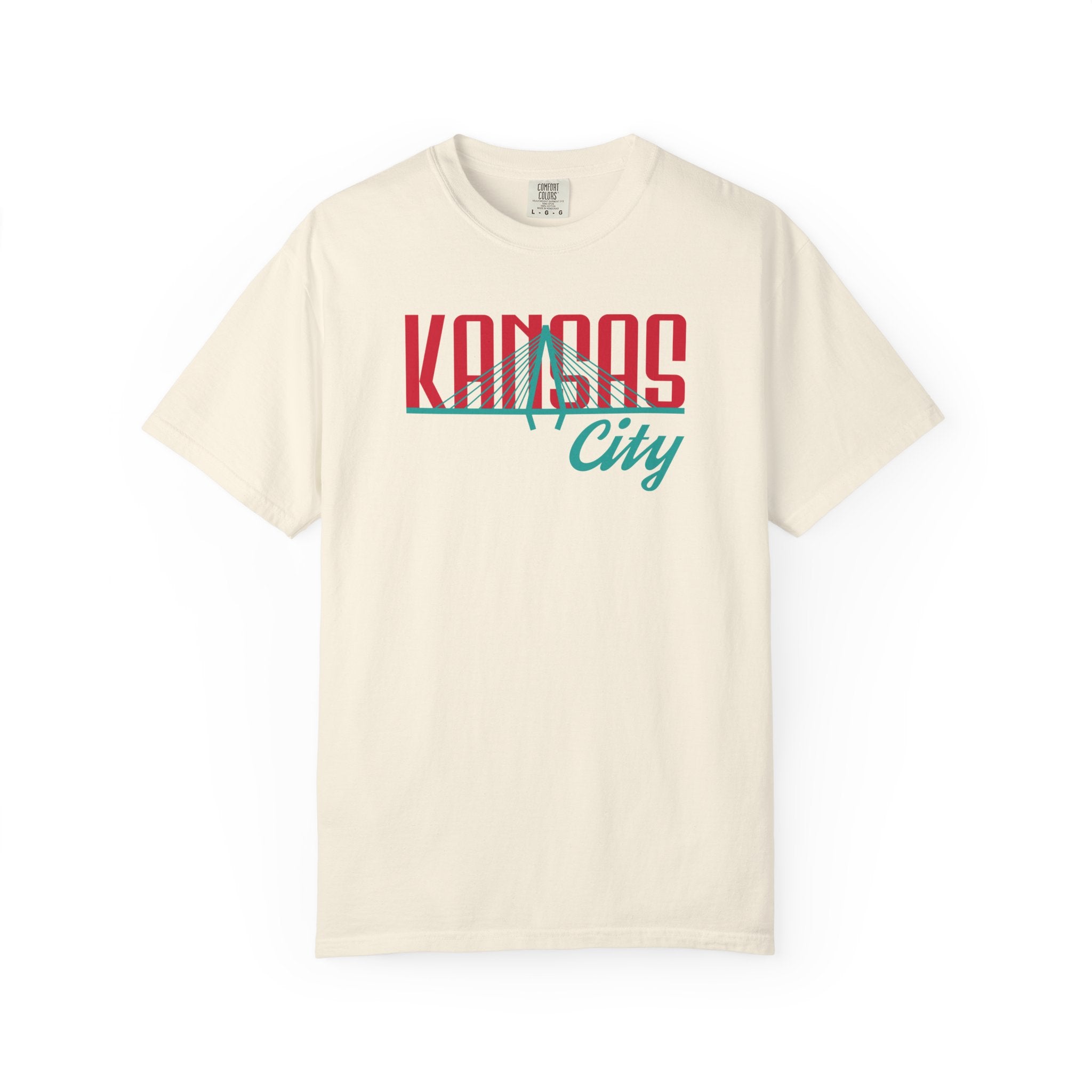 Ivory garment-dyed t-shirt front view featuring "Kansas City" with bridge graphic in red and teal retro script across the chest.