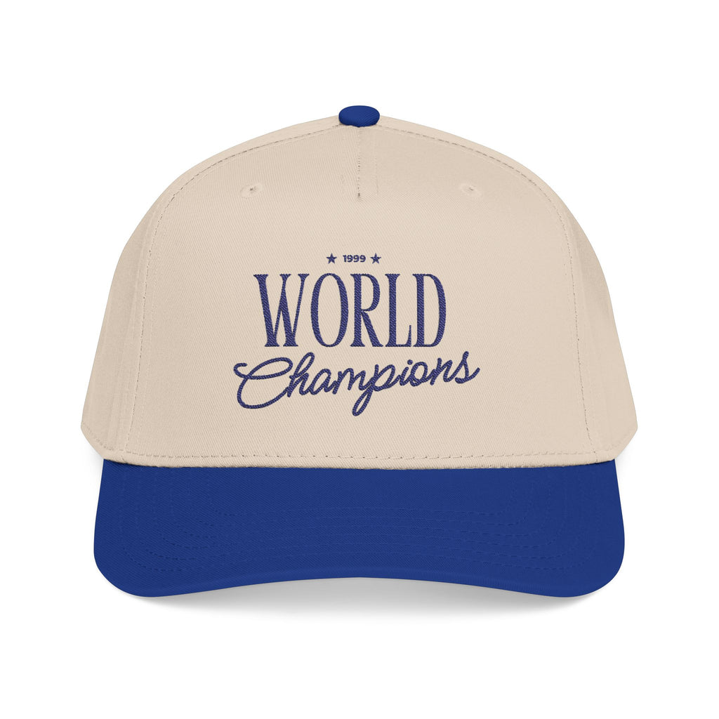 A two-tone baseball cap with an off-white crown and a royal blue brim, featuring '1999 World Champions' embroidered in blue on the front.