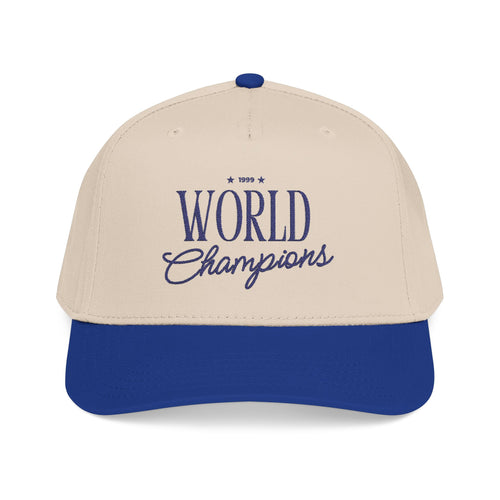 A two-tone baseball cap with an off-white crown and a royal blue brim, featuring '1999 World Champions' embroidered in blue on the front.