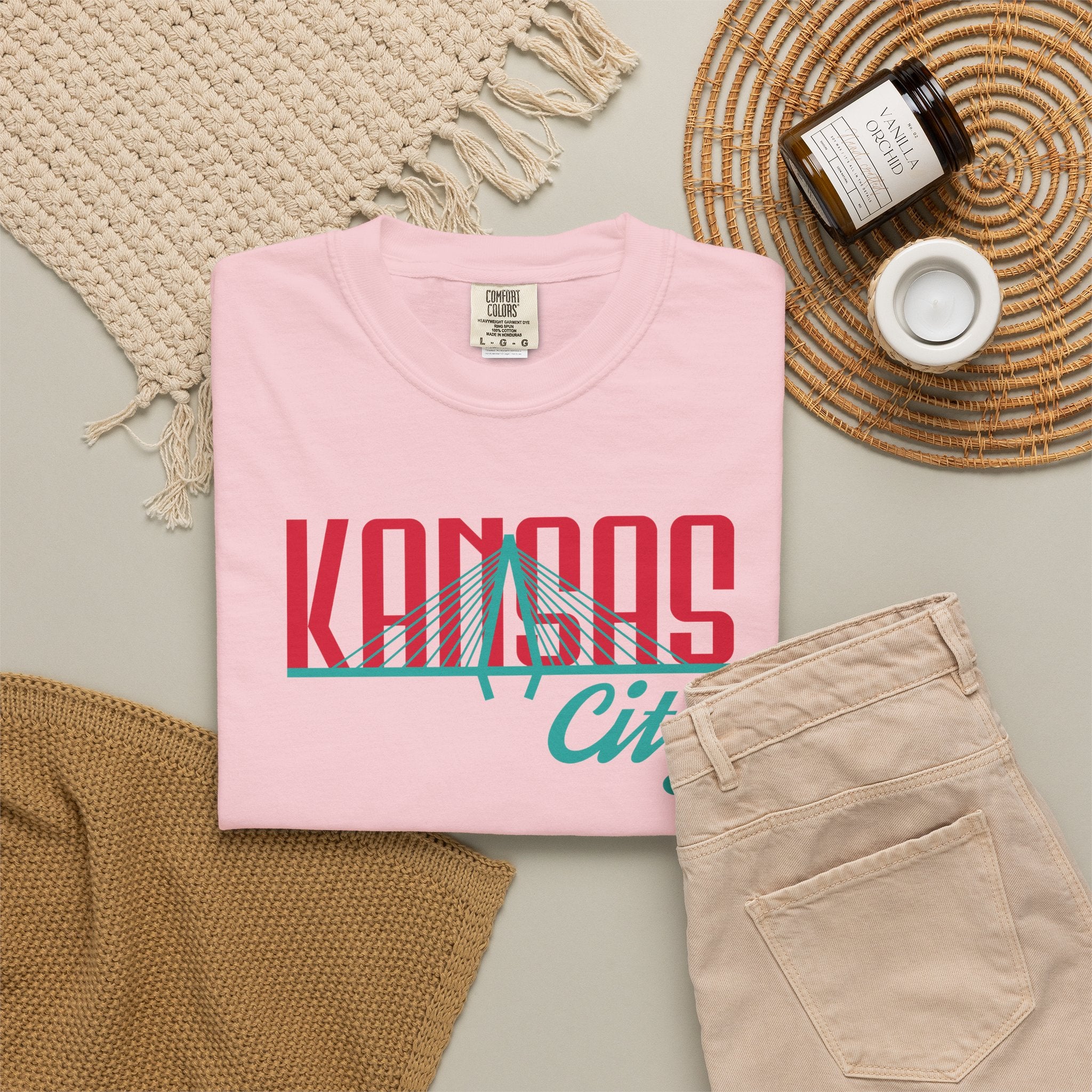Blossom pink garment-dyed t-shirt front view featuring "Kansas City" with bridge graphic in red and teal retro script across the chest.