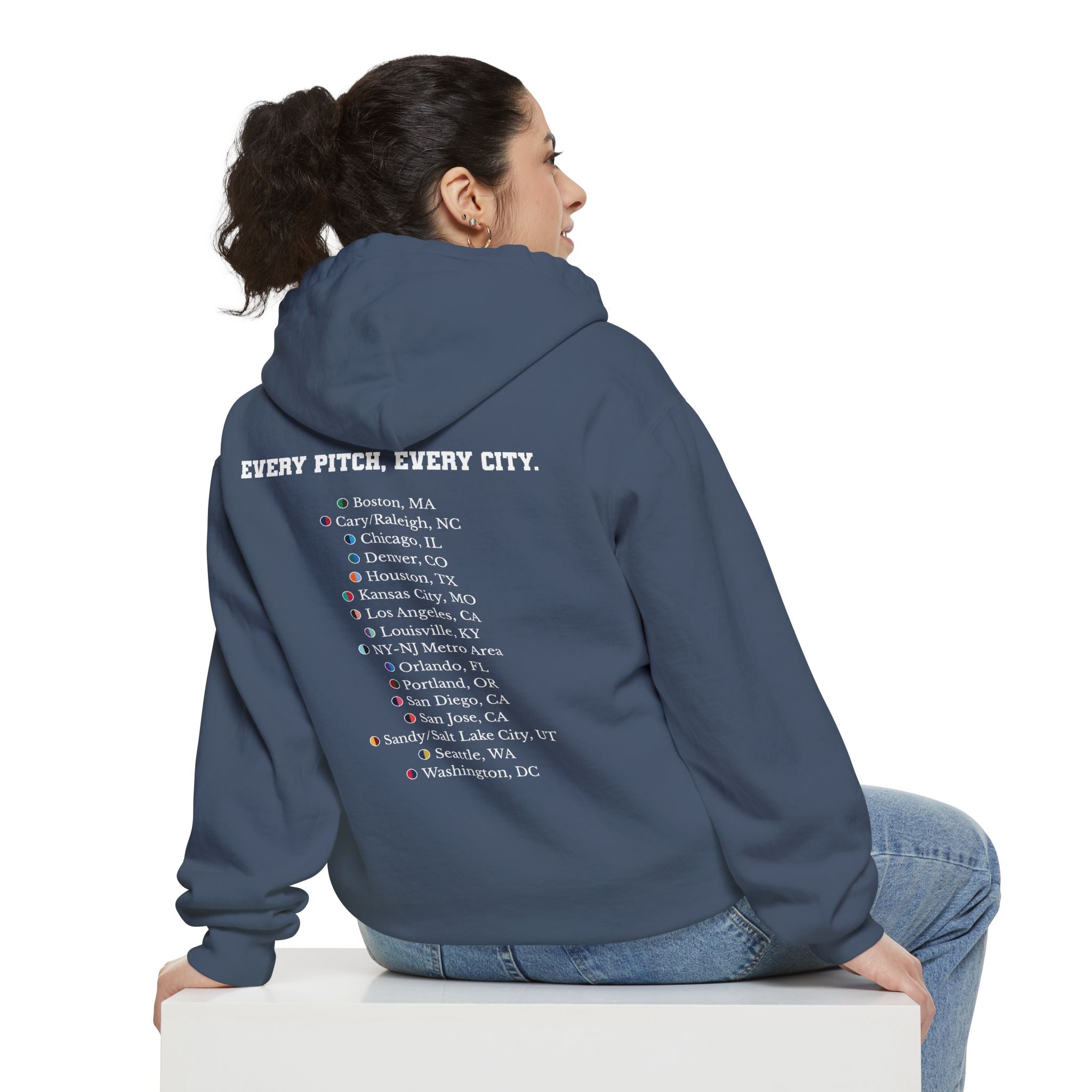Denim colored hoodie with chest logo on the front and list of cities on the back