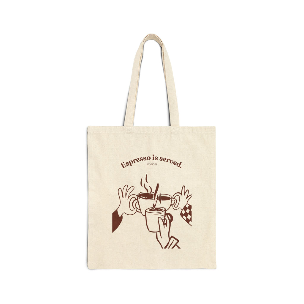 Canvas tote bag featuring an Espresso is served graphic with three clinking coffee mugs on the back and a front pocket W logo from The W-League collection