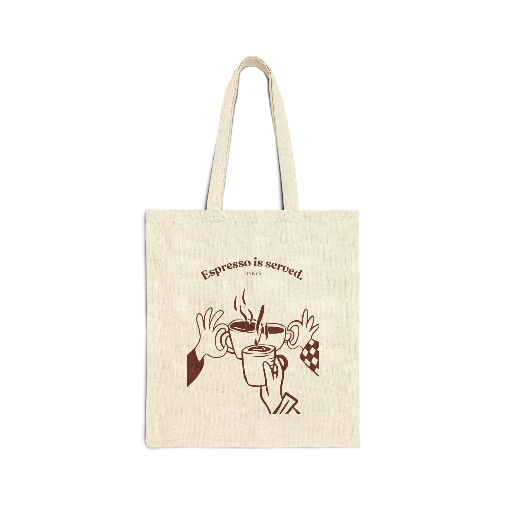 Canvas tote bag featuring an Espresso is served graphic with three clinking coffee mugs on the back and a front pocket W logo from The W-League collection